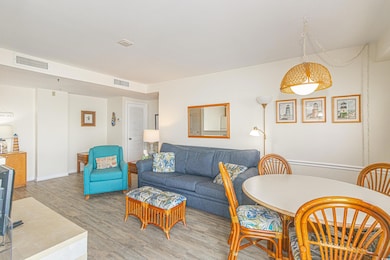 Living room with light wood-style flooring, baseboards, and visible vents