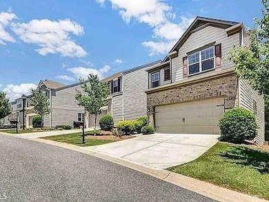 View of front of property featuring a residential view, driveway, and an attached garage