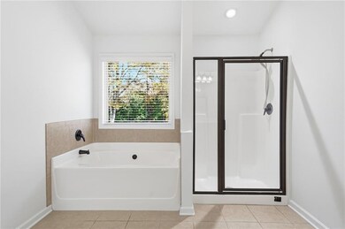 Full bathroom with light tile patterned floors, a bath, a stall shower, and recessed lighting