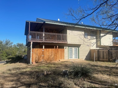 Rear view of property featuring a balcony, french doors, and a metal roof