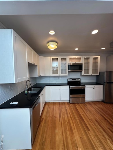 Kitchen with white cabinets, stainless steel appliances, tasteful backsplash, and recessed lighting