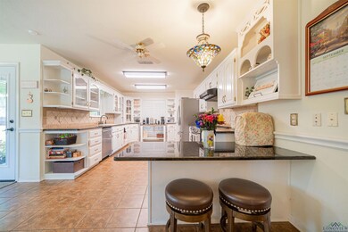 Kitchen featuring a kitchen bar, appliances with s
