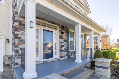 Doorway to property featuring a porch and stone siding