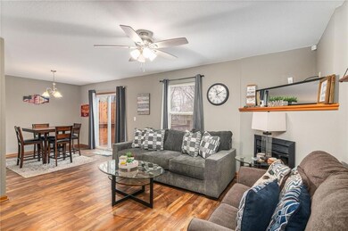 Living room featuring wood-type flooring and ceiling fan with notable chandelier