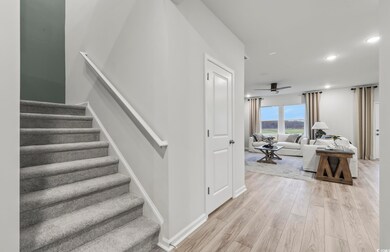 Stairway with wood finished floors, ceiling fan, baseboards, and recessed lighting