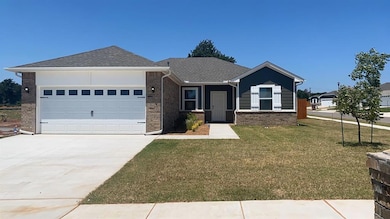 Ranch-style home with a front yard, brick siding, roof with shingles, concrete driveway, and a garage