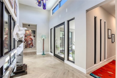 Corridor with baseboards and a towering ceiling