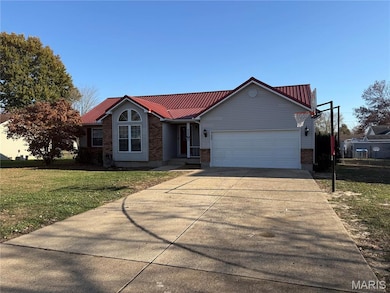 Ranch-style home featuring brick siding, a front yard, a metal roof, driveway, and an attached garage