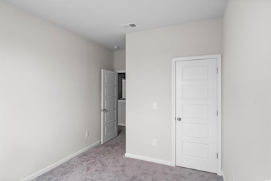 Unfurnished bedroom with light colored carpet