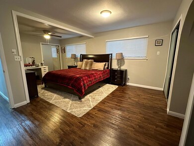 Bedroom with ceiling fan and dark wood-type flooring