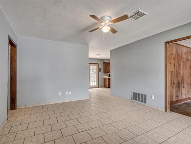 Spare room with a textured ceiling, ceiling fan, and light tile floors