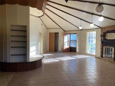 Unfurnished living room with tile patterned flooring, vaulted ceiling with beams, built in shelves, and a brick fireplace
