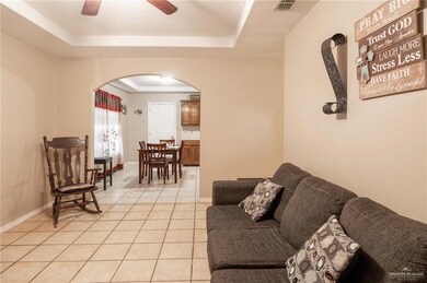 Tiled living room with a raised ceiling and ceiling fan