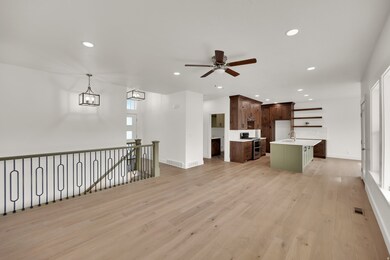Unfurnished living room with recessed lighting, light wood-type flooring, a ceiling fan, and a chandelier
