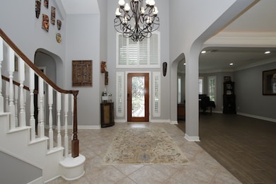 Two story entry with elegant chandelier and planta