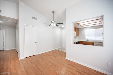 Unfurnished living room featuring a ceiling fan, l