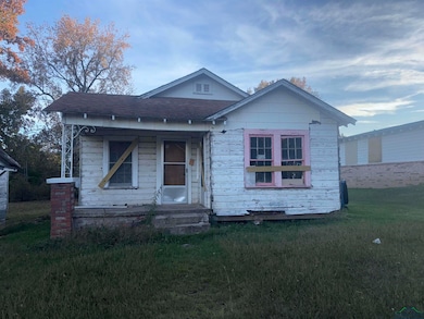 Bungalow with a front lawn, a porch, and roof with shingles