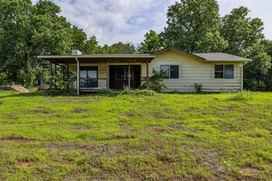 Single story home featuring a front yard, a chimney, and covered porch