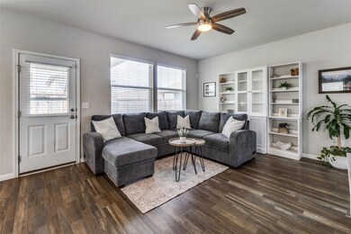 Living room with ceiling fan, dark wood-style flo