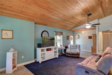  living area featuring lofted ceiling, a ceiling fan, and wooden ceiling
