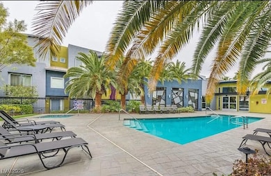 Lush gated community pool with a patio