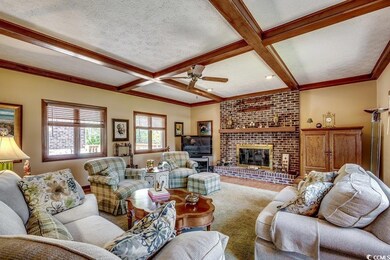 Living room featuring beam ceiling, a ceiling fan,
