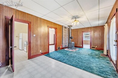 Unfurnished room with wood walls, and wood stove