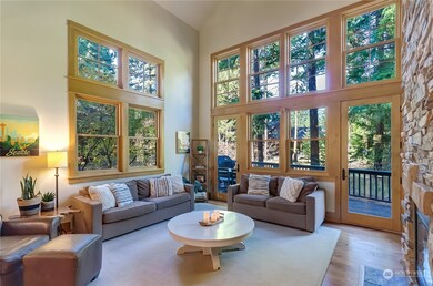 The oversized and grand family room offers walls of windows, stack stone fireplace, and plenty of 