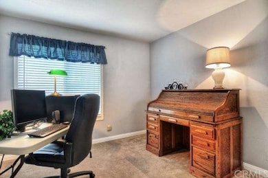 The first bedroom down the hallway on the right is also spacious in size and the window looks out to the front yard. The room is perfect for an office area or to be used as a guest bedroom.  The bedroom also features newer carpet. 