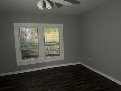 Spare room with dark wood-type flooring and ceiling fan