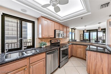 Kitchen featuring dark stone counters, sink, light