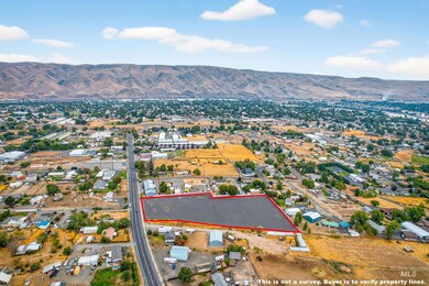 Aerial overview of property's location with property boundaries highlighted and a mountainous background