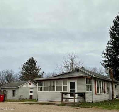 Back of property featuring a chimney and a sunroom