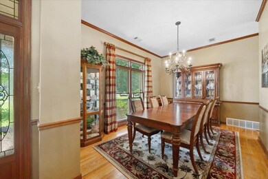 Dining area featuring light wood-style flooring, a chandelier, plenty of natural light, crown molding, and baseboards