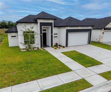View of front facade featuring a garage and a front lawn