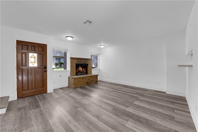 Unfurnished living room featuring wood finished fl