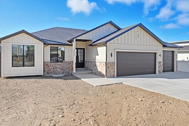 Modern farmhouse with board and batten siding, concrete driveway, a shingled roof, an attached garage, and stone siding