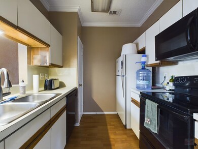 Kitchen with black appliances, dark wood-type flo