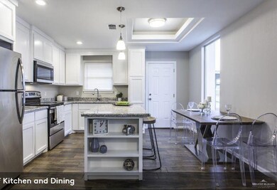 Kitchen featuring open shelves, white cabinets, visible vents, a raised ceiling, and appliances with stainless steel finishes