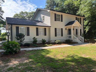 Colonial inspired home featuring a front yard and roof with shingles