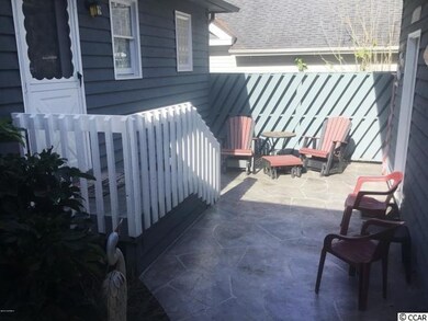 Courtyard access to kitchen and storage alongside the back of garage
