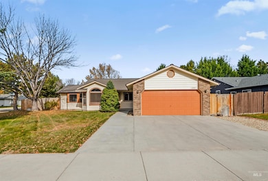 Ranch-style house with concrete driveway, an attached garage, and brick siding