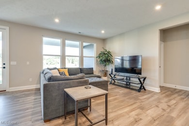 Living area featuring recessed lighting, light wood finished floors, and a textured ceiling