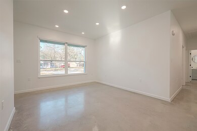 The living room features large windows that flood the space with natural light, creating a bright and airy atmosphere. This open design seamlessly connects the living room to the kitchen, promoting a sense of flow and spaciousness.
