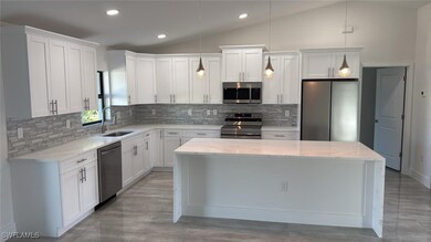 Kitchen with lofted ceiling, a sink, stainless ste