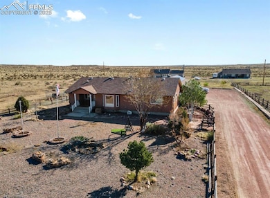 View of front of house with a rural view, fence, a