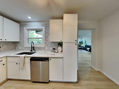 Kitchen featuring a sink, backsplash, light wood-s