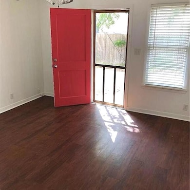 Spare room with dark wood-type flooring and baseb