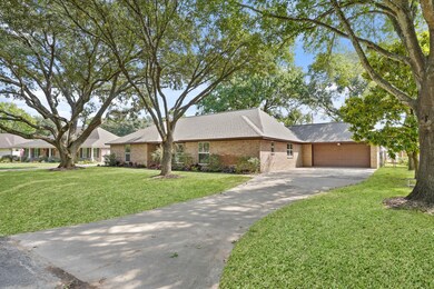 Long driveway and manicured lawn lead to a beautifully kept exterior with inviting curb appeal.