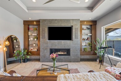 Living room with built in features, a tray ceilin